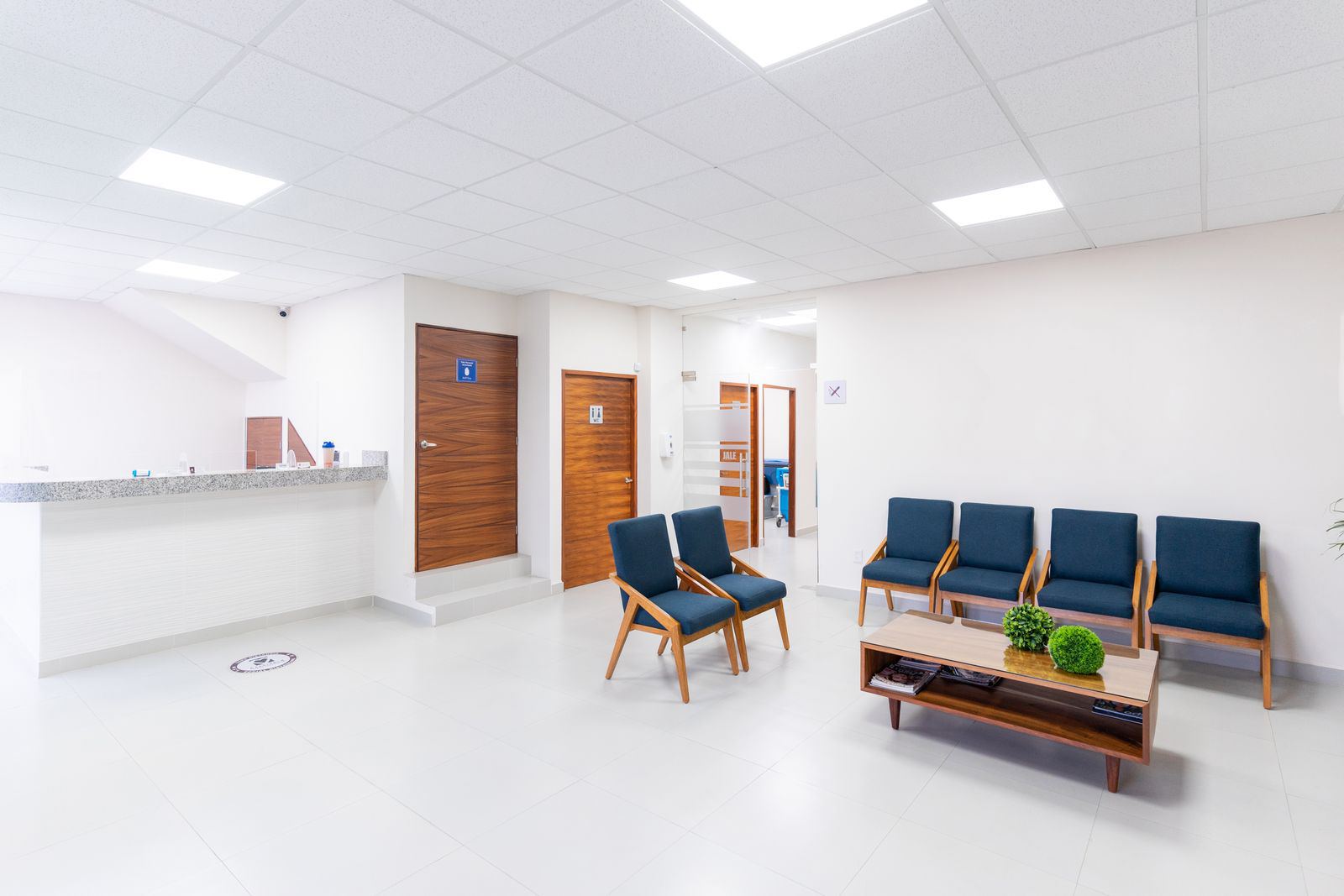 A clean, empty medical waiting room with rows of seating