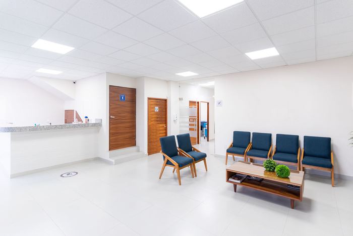 A clean, empty medical waiting room with rows of seating